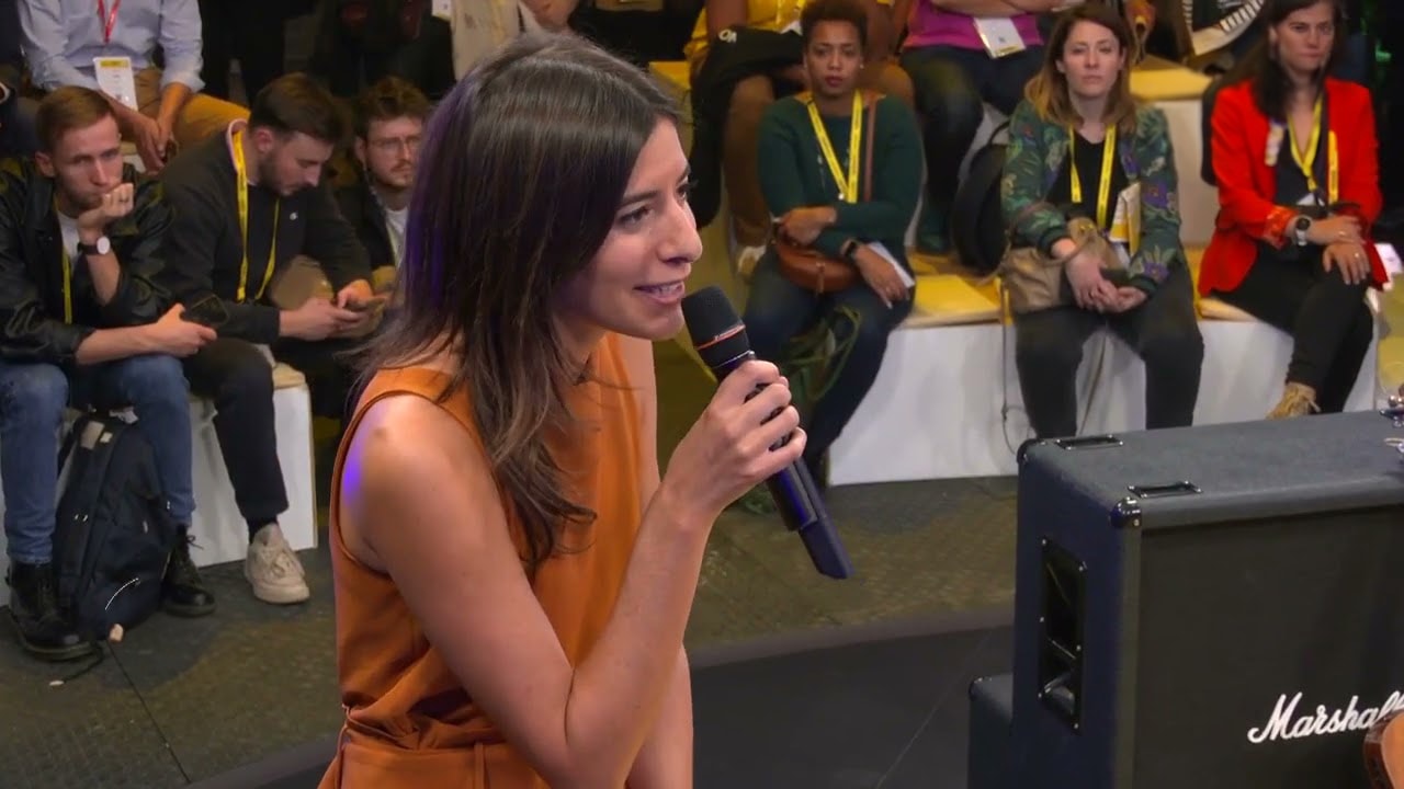 Photo of rows of books in a library with marble busts.